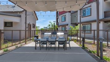 A patio with a dining table and chairs under a canopy